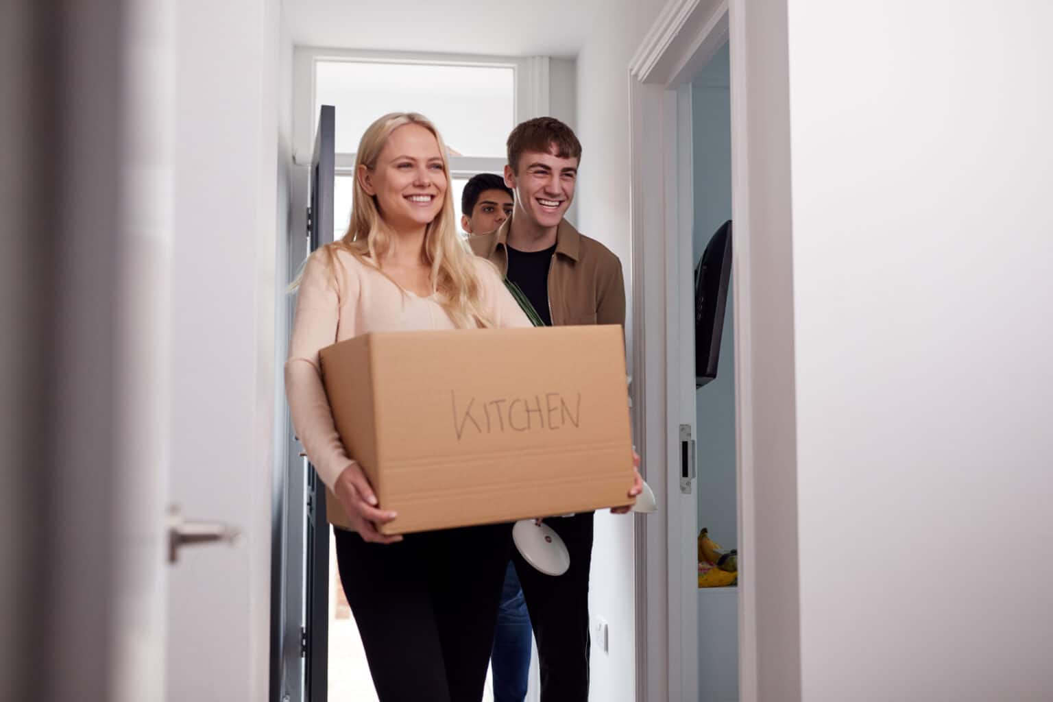 Group Of College Student Carrying Boxes Moving Into Accommodation Together